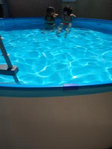 Dos personas en una piscina de agua azul en Casa Rural Alamar en Tiedra