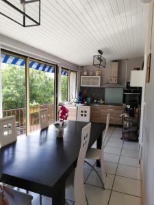 a kitchen with a black table and chairs in a room at atmosphere in Poilhès