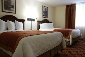 a hotel room with two beds and a window at Hawthorn Suites by Wyndham Louisville East in Louisville