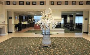 um grande lobby com uma mesa com flores em Hawthorn Suites by Wyndham Louisville East em Louisville