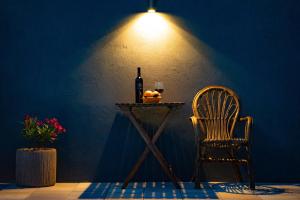 a table with a bottle of wine and a chair at Apartments Mardešić in Komiža