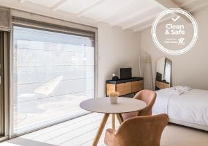 1 dormitorio con 1 cama, mesa y sillas en Malmerendas Boutique Lodging, en Oporto
