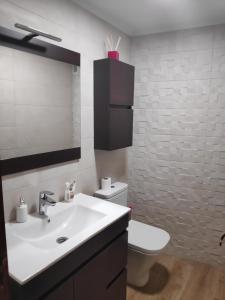 Amplio apartamento con todas las comodidades en Oviedo في أوفِييذو: حمام مع حوض ومرحاض ومرآة