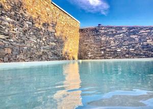 uma piscina de água junto a uma parede de tijolos em Morgadio da Calcada Douro Wine&Tourism em Provesende