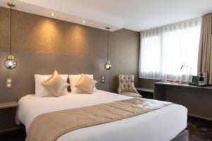 シャントピにあるThe Originals City, Hôtel Rennes Sudの大きなベッドと机があるホテルの部屋
