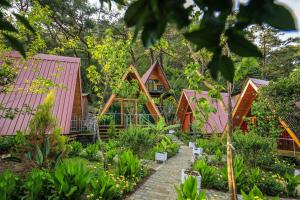 a row of houses with pink roofs in a garden at Likya Evleri Olympos in Olympos