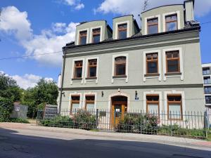 uma casa cinzenta com uma vedação à frente. em 999 Aparthostel em Cracóvia