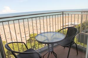 balcone con tavolo, sedie e spiaggia di International Seaview Apartments a Lignano Sabbiadoro