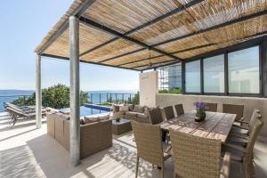 a patio with a table and chairs and a view of the ocean at Villa Lipa in Jesenice