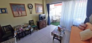 uma sala de estar com uma televisão e uma mesa e cadeiras em Apartamento Osos em Puerto de Santiago