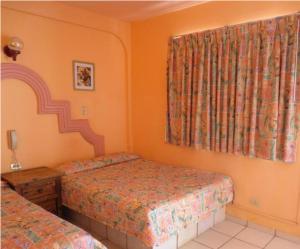 a bedroom with two twin beds and a window at Hotel Plaza Peñasco in Puerto Peñasco +21 photos