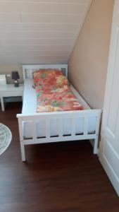 a white bed with a floral blanket on it at Ferienwohnung am kleinen Stadtpark Langenselbold in Langenselbold