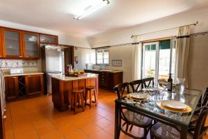 eine Küche mit einem Tisch und Stühlen sowie eine Küche mit einem Kühlschrank in der Unterkunft Casa do moleiro in Encarnação