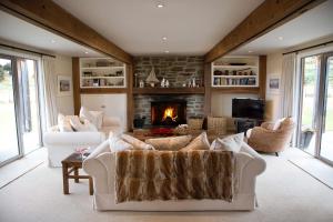 a living room with two white couches and a fireplace at Buchanan Lodge - 60 acres on Wanaka lakefront in Wanaka