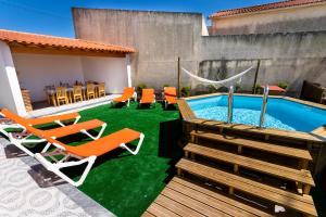 einen Hinterhof mit einem Pool, Stühlen und einem Tisch in der Unterkunft Casa do moleiro in Encarnação