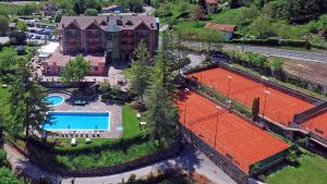 an aerial view of a large house with a tennis court at Club Hotel Tenno in Tenno