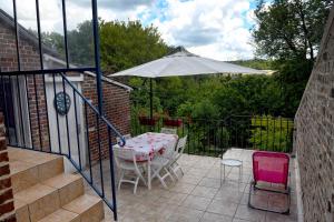 un patio con mesa, sillas y sombrilla en L'escale Arquaise, la maison au jardin fleuri à 5 min de dieppe en Arques-la-Bataille