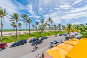 un aparcamiento con coches y palmeras en la playa en SoBe Lux Suites On Ocean en Miami Beach