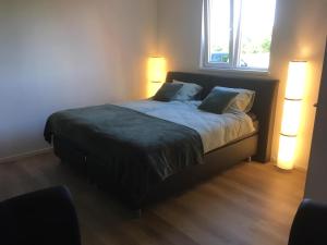 Luxury Lodge Veere في فيري: غرفة نوم بها سرير مع مصباحين