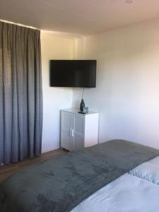 um quarto com uma cama e uma televisão de ecrã plano na parede em Luxury Lodge Veere em Veere