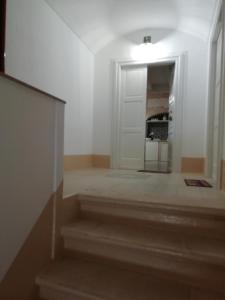 - un couloir avec des escaliers avec une porte blanche et une table dans l'établissement I due campanili, à Alberobello