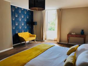 1 dormitorio con 1 cama y 1 silla amarilla en Le Clos Ayanna, en Crémieu