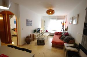 sala de estar con sofá y ventana en Livingtarifa Apartamento Atardecer, en Tarifa