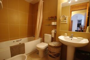 y baño con lavabo, aseo y bañera. en Livingtarifa Apartamento Atardecer, en Tarifa