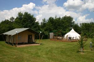 a couple of tents in a field with trees at Safari at La Petite Lande in Pierrefiche