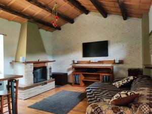 un salon avec un canapé et une télévision à écran plat dans l'établissement Il Corbezzolo, à Ripatransone