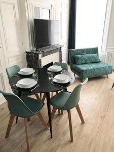 een woonkamer met een tafel en stoelen en een bank bij La Savane du Donjon in Rouen