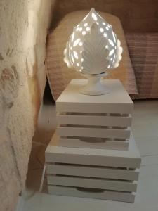 une lampe assise au-dessus d'une pile de boîtes dans l'établissement I due campanili, à Alberobello