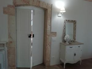 Cette chambre dispose d'une porte blanche et d'un miroir. dans l'établissement I due campanili, à Alberobello