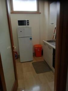 małą kuchnię z białą lodówką i oknem w obiekcie B&B DUOMO w mieście Benewent