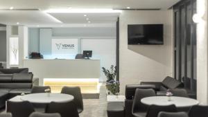uma sala de espera com mesas e cadeiras e um balcão em Venus Minimal Hotel em Tinos Town