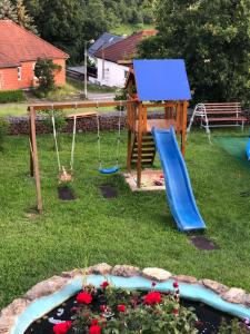 un parque infantil en un patio con tobogán en Haus Am Wald en Wasungen