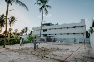 eine Gruppe von Menschen, die am Strand Volleyball spielen in der Unterkunft Inn Tribus Hotel in Flecheiras
