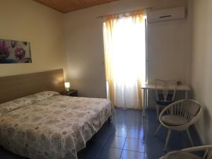 a bedroom with a bed and a table and a window at Appartamento Stella del mare in Trapani