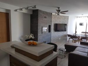 una sala de estar con una mesa con un bol de naranjas en Apartament Los Planetas, en Alicante