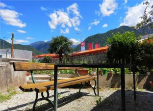 a bench in a park with mountains in the background at Apartma 2000 Tolmin in Tolmin