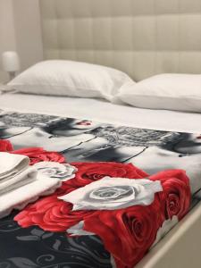 Una cama con una manta con rosas. en Al Porto, en Gaeta
