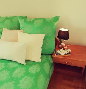a green couch with pillows and a table with a lamp at Villa Laurea in Lovran