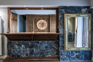 un miroir sur un mur à côté d'un mur en pierre dans l'établissement Hosteria y Restaurante America, à Ushuaia