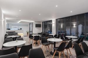 uma sala de reuniões com mesas e cadeiras num edifício em Venus Minimal Hotel em Tinos Town