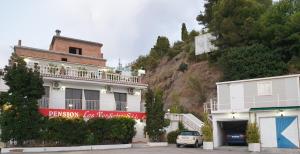 a building on the side of a mountain at Pension los Verdiales in La Herradura