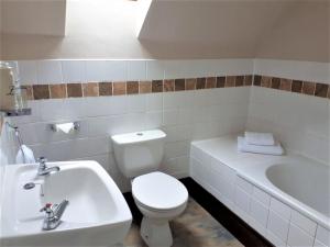 a bathroom with a toilet and a sink and a tub at Corsewall Arms Guest House in Stranraer