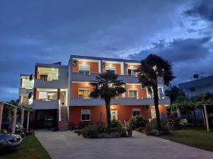 un edificio con dos palmeras delante en Robi Apartments, en Ulcinj