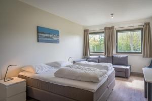 a living room with a bed and a couch at familiewoning Orchismient 24 in De Koog