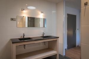 a bathroom with two sinks and a mirror at familiewoning Orchismient 24 in De Koog