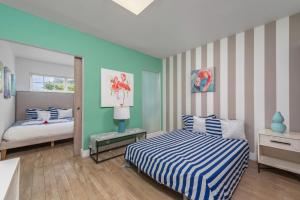 1 dormitorio con 2 camas y pared a rayas en SoBe Lux Suites On Ocean en Miami Beach